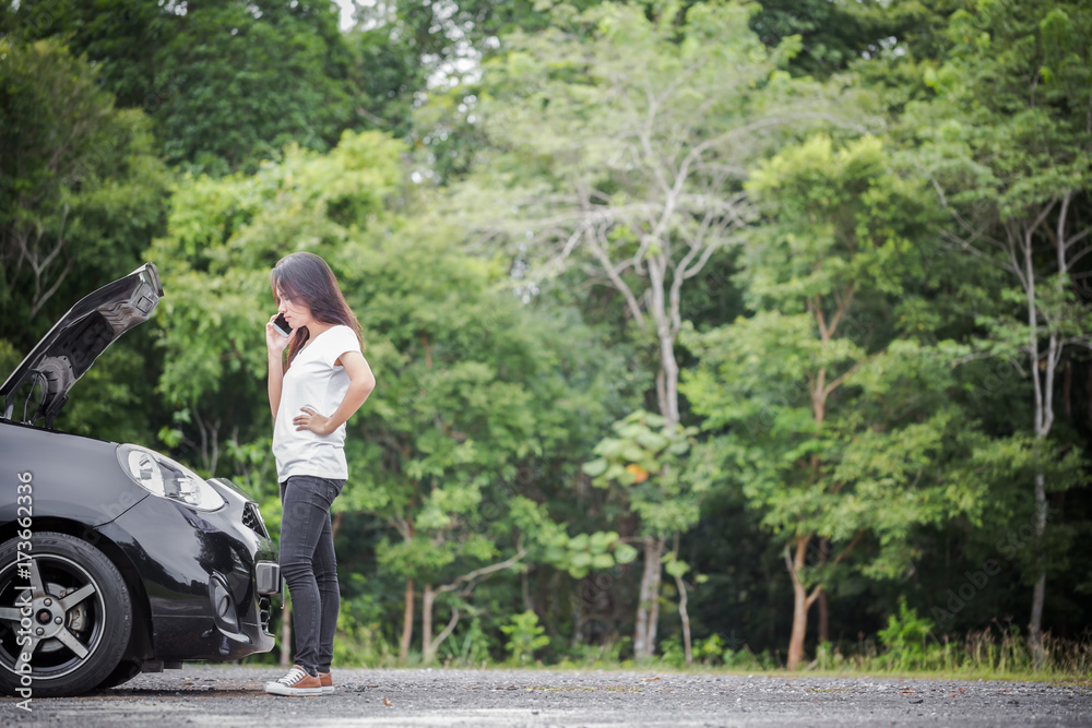 Broken down car and asian woman calling car mechanic Broken down car and asian woman calling car mechanic