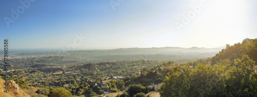 Fotografie, Obraz Panoramic view of sunrise over the village and green landscape in Mijas