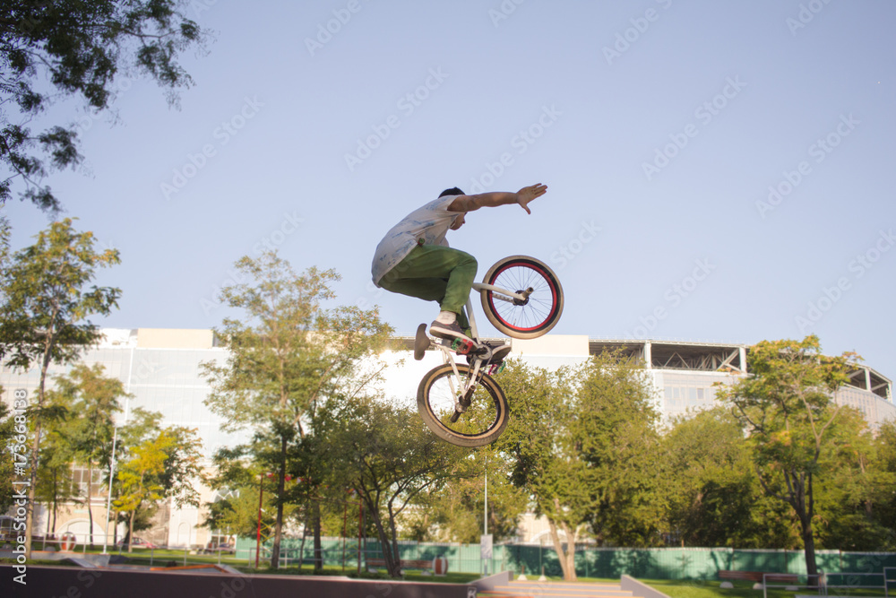 Obraz premium BMX rider training and do tricks in street plaza, bicyxle stunt rider in cocncrete skatepark
