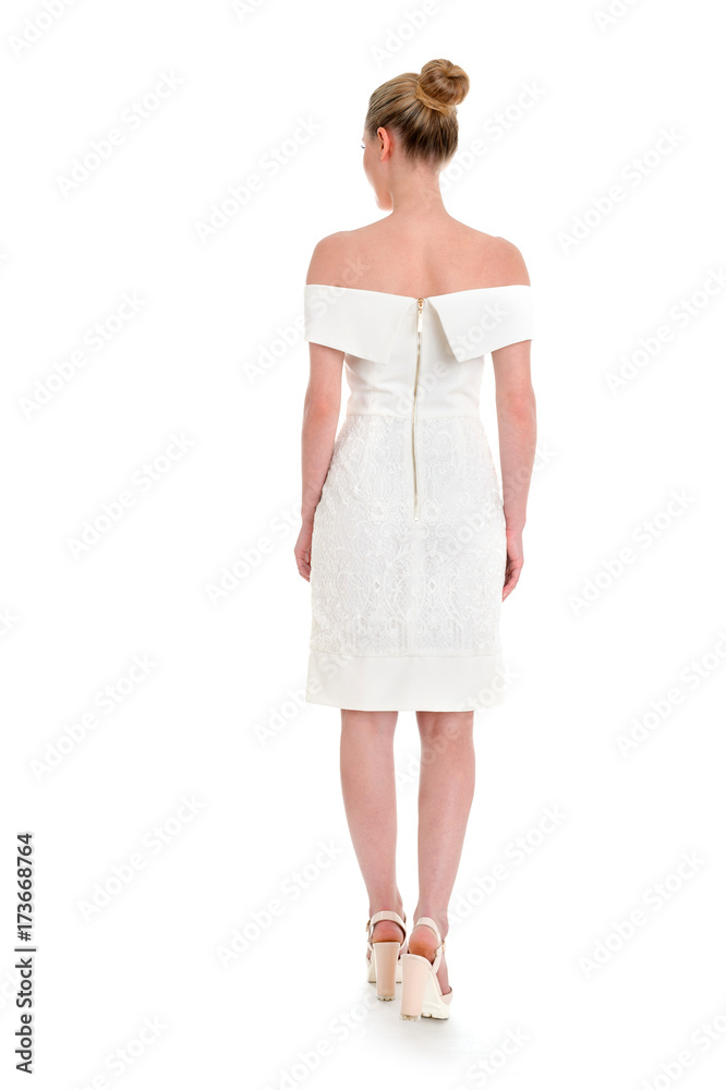Back view of a young beautiful woman posing in a white short dress and high heels Back view of a young beautiful woman posing in a white short dress and high heels