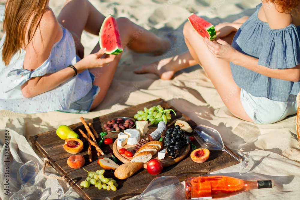 Two young female friends on the sea shore enjoying with watermelon.