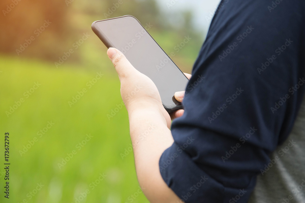 © suparat1983 - people holding smartphone with nature background.