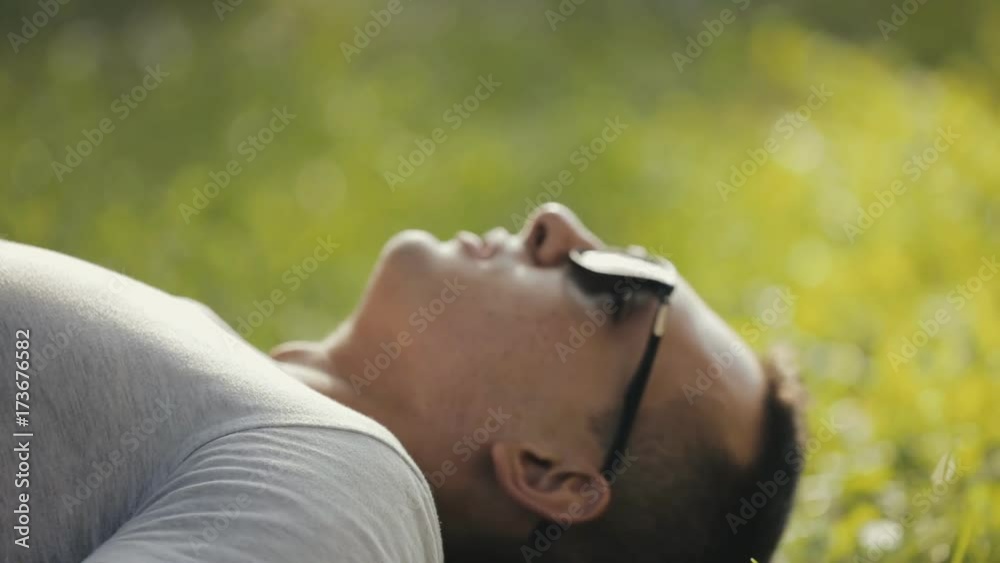 Happy young couple lying on grass in park, she kiss him forehead Happy young couple lying on grass in park, she kiss him forehead