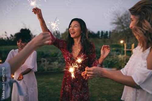 Multi-ethnic friends enjoying party with sparklers
