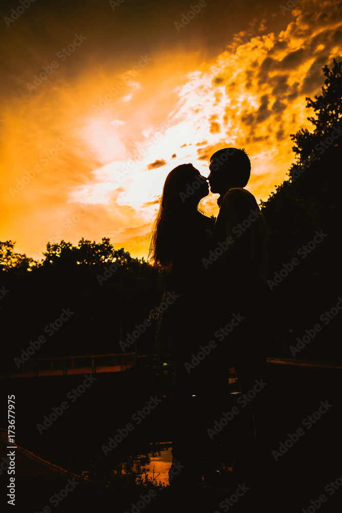 Beautiful young couple on the sunset background