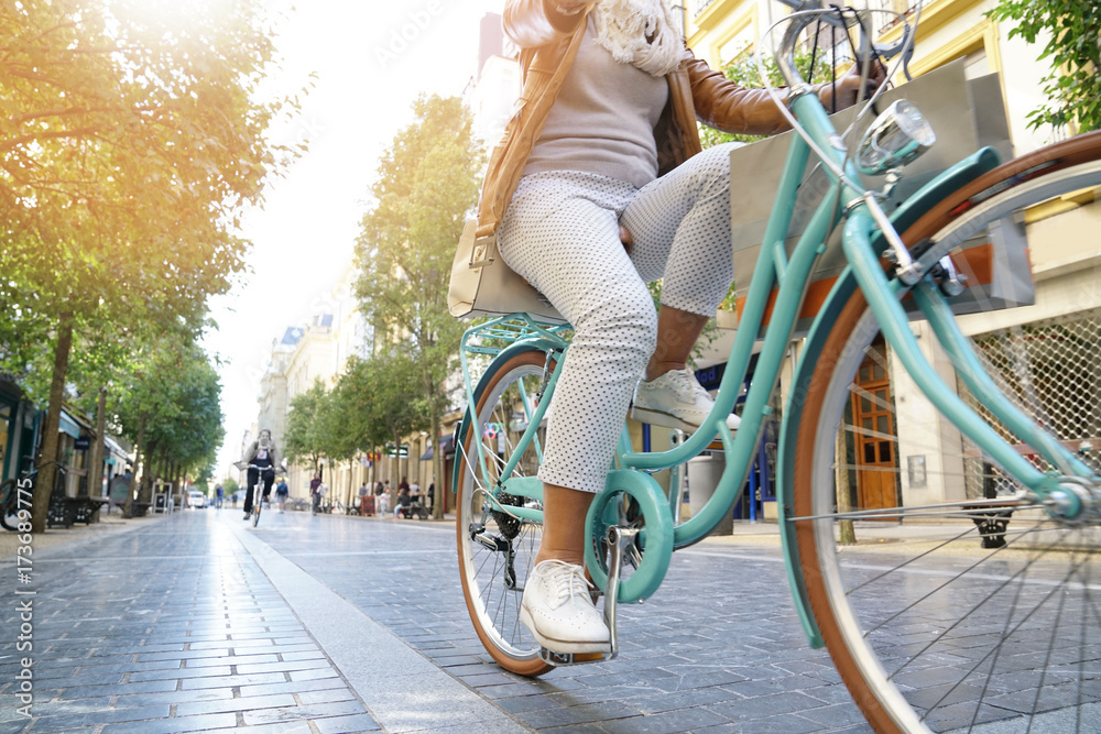 Fototapeta premium Starszy kobieta jedzie na rowerze miejskim w mieście