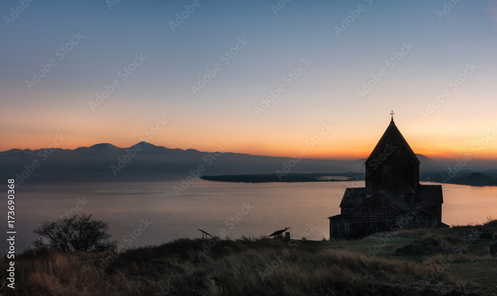 Panoramic view of the temple complex on the Sevan Lake at sunset, Armenia. Silhouettes of St. Jakob Church and Sevanavank. Armenian landmarks