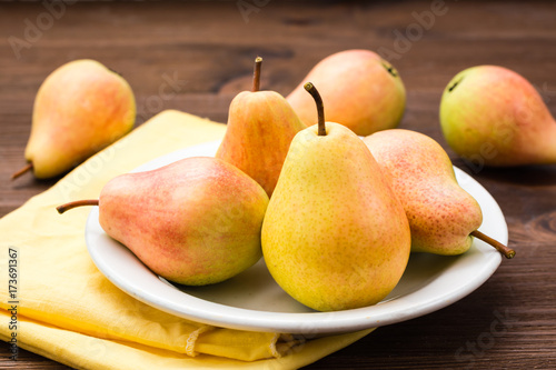 Ripe pears on a plate on a wooden table