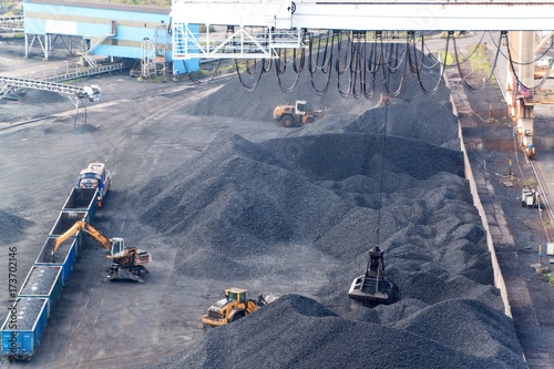 Work in port coal transshipment terminal. Coal unloading of wagons with special cranes. Working in a port near the Baltic Sea. photo