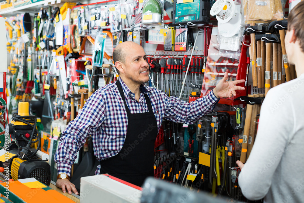 Friendly salesman showing hammer to client