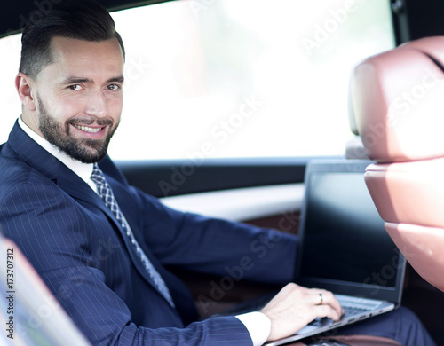 Close-up of a businessman with a laptop sitting in the car © ASDF