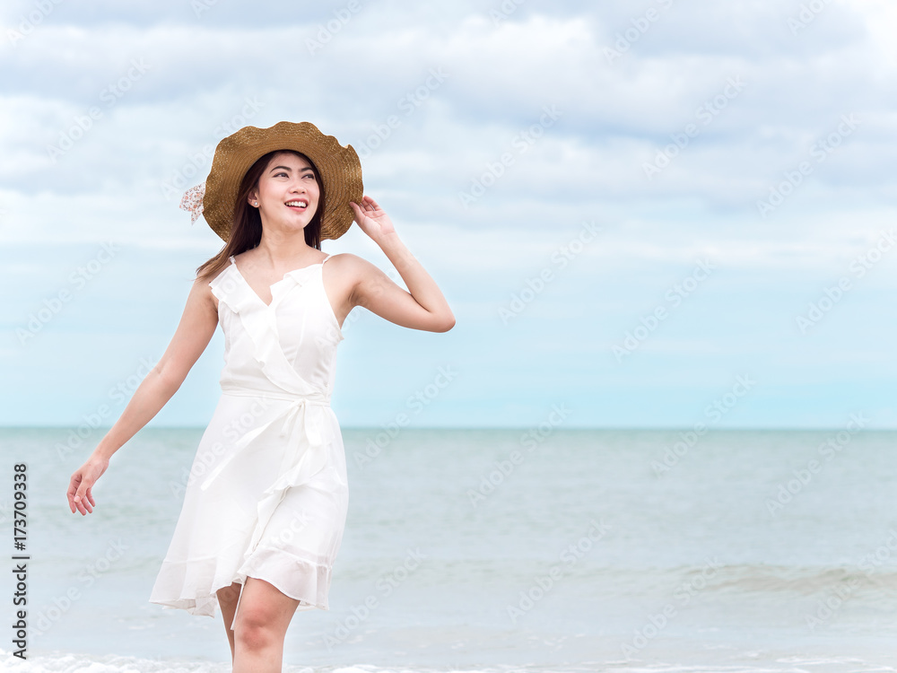 Beautiful Asian woman with white dress on the Thailand beach, sea, sky in summer feeling happy and relax on holiday vacation season Beautiful Asian woman with white dress on the Thailand beach, sea, sky in summer feeling happy and relax on holiday vacation season