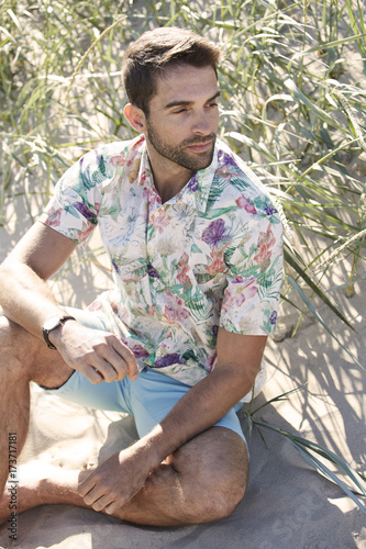 Beach guy in floral shirt and shirts, looking away