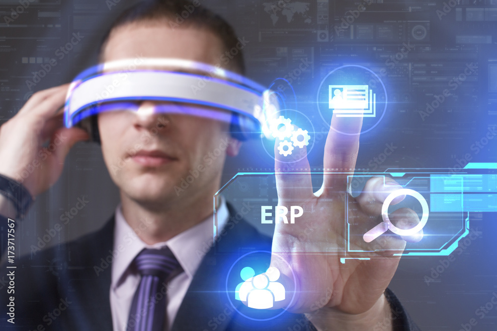 Business, Technology, Internet and network concept. Young businessman working in virtual reality glasses sees the inscription: ERP Business, Technology, Internet and network concept. Young businessman working in virtual reality glasses sees the inscription: ERP