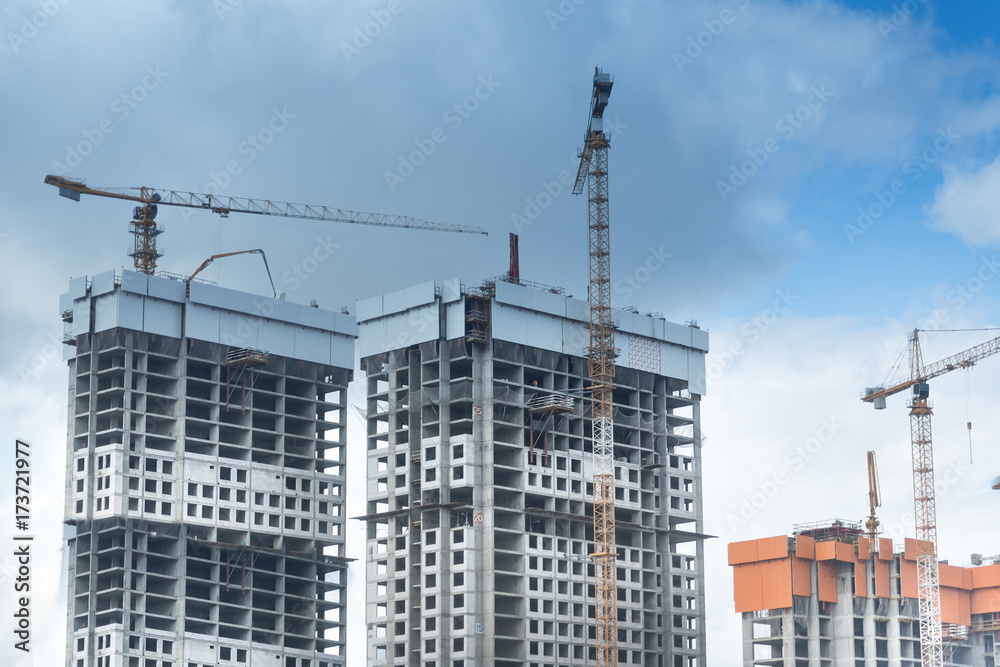 Crane and building construction site against blue sky