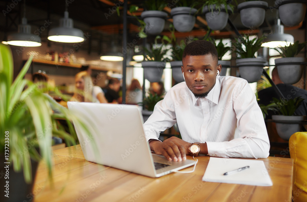African man working at cafe with laptop. African man working at cafe with laptop.