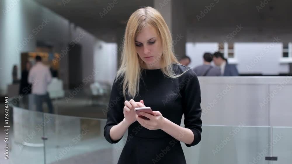 Business Woman With Phone in Business Center Lobby Business Woman With Phone in Business Center Lobby