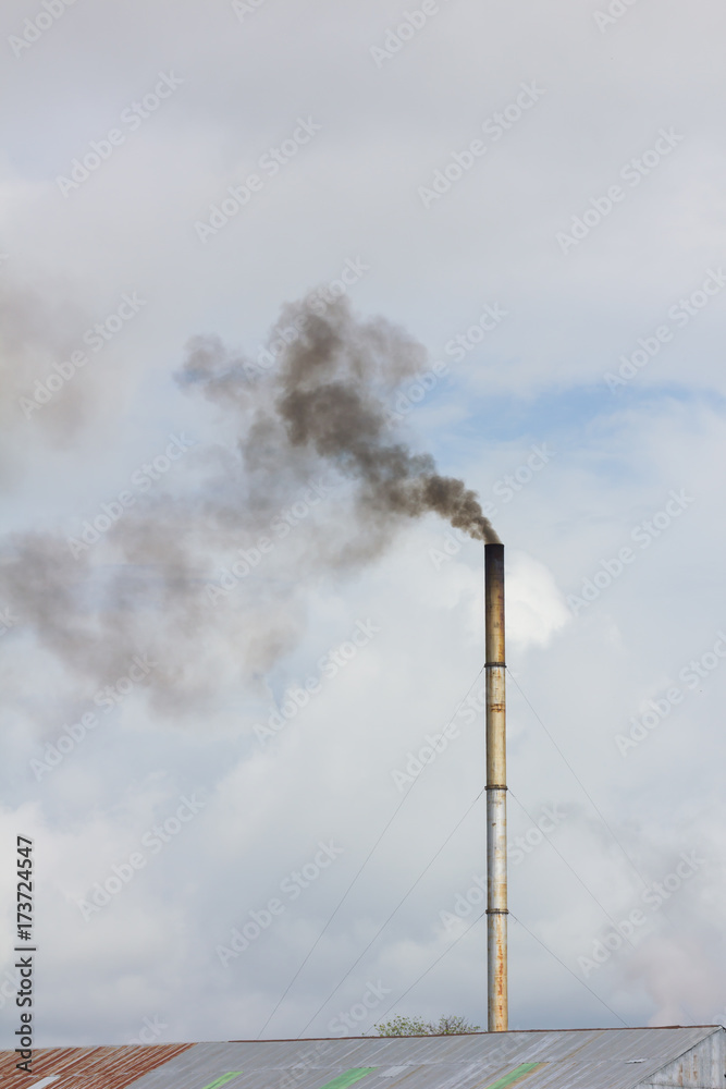 smoke from chimney of rice mill in thailand, vertical photo.