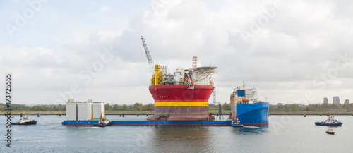 Cargo ship is carrying the oil platform.