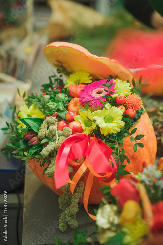 Flower arrangement with pumpkin with red bow. Autumn. Holiday photo