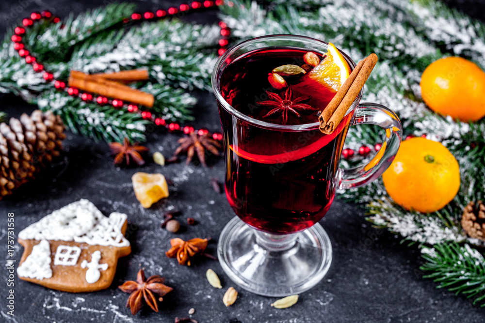 Christmas mulled wine with spices in cup on dark background Christmas mulled wine with spices in cup on dark background