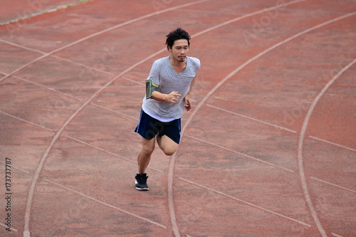 Lifestyle of young healthy Asian runner man running on racetrack in stadium © tuaindeed