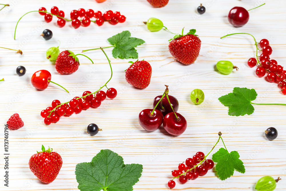 Colorful delicious fresh fruit strawberries, cherries, currants and raspberries on white wooden background. Beautiful, delightful and healthy desserts Colorful delicious fresh fruit strawberries, cherries, currants and raspberries on white wooden background. Beautiful, delightful and healthy desserts