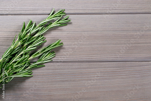 Organic bunch of fresh rosemary on the old grey wooden background. Free space for your text