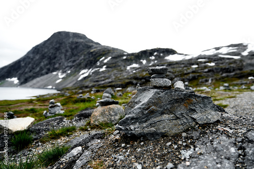 Hiking stones in focus with snow covered mountains and a lake in the unsharp background in norway