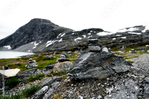 Hiking stones in focus with snow covered mountains and a lake in the unsharp  background in norway