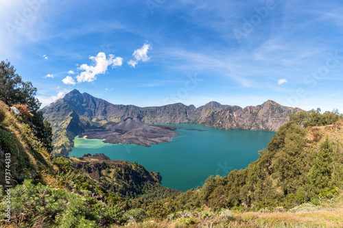 Panorama landscape of active volcano Baru Jari, Lake Segara Anak and summit of Rinjani mountain. Lombok island, Indonesia.