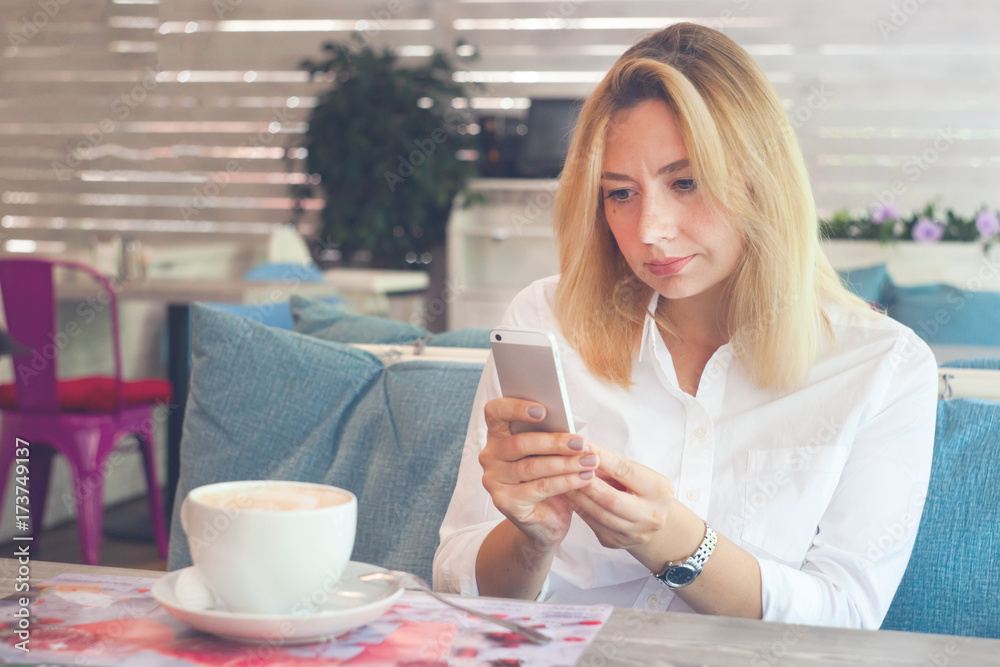 Woman holding mobile phone in a cafe, toned photo Woman holding mobile phone in a cafe, toned photo