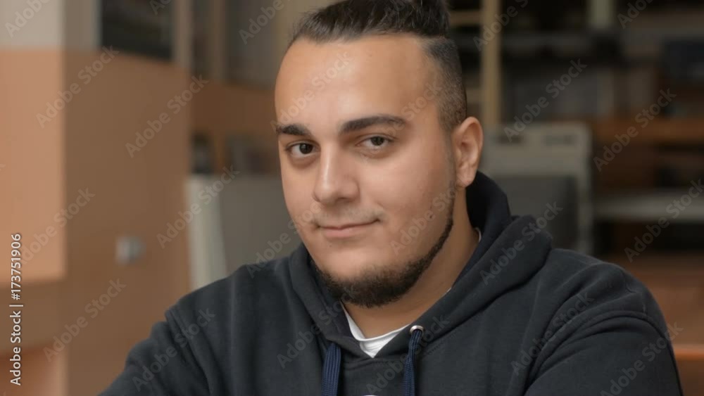 Close-up portrait of a young male. Asian man smiling indoors. Successful student in the classroom
