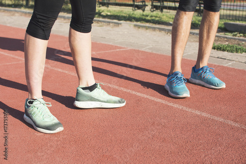 Close up mans and woman's legs on running track.