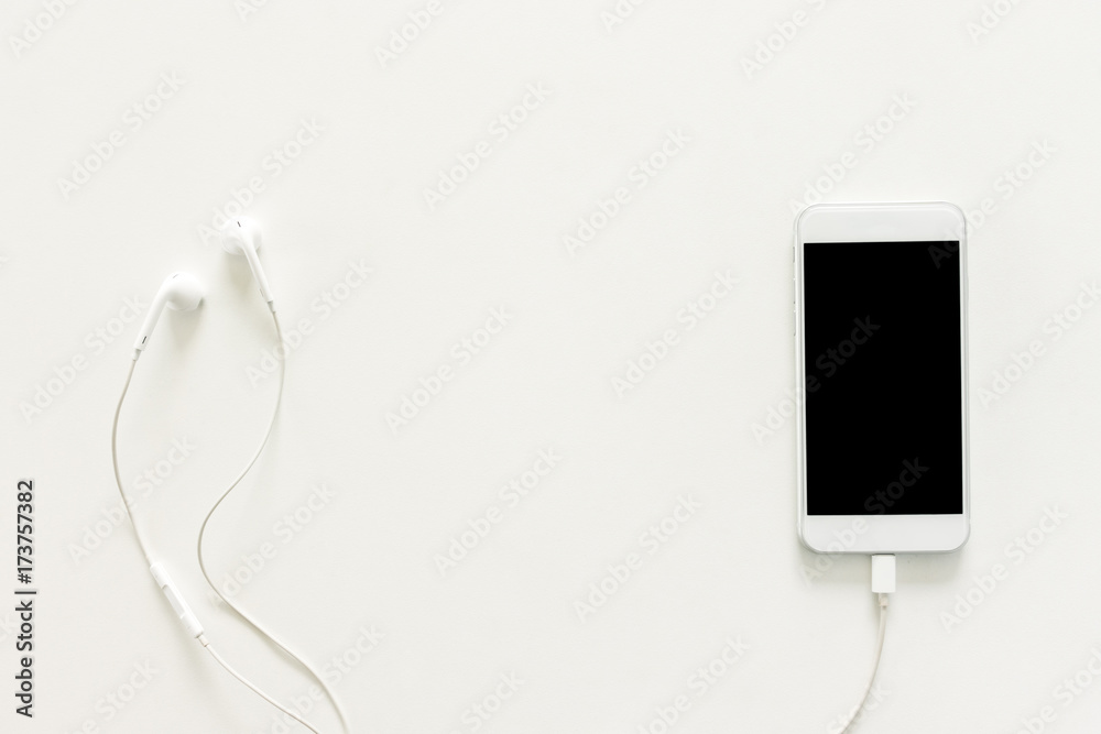 Minimal work space - Creative flat lay photo of workspace desk with earphones and mobile phone with blank screen on copy space white background. Top view mock up , flat lay photography. Minimal work space - Creative flat lay photo of workspace desk with earphones and mobile phone with blank screen on copy space white background. Top view mock up , flat lay photography.