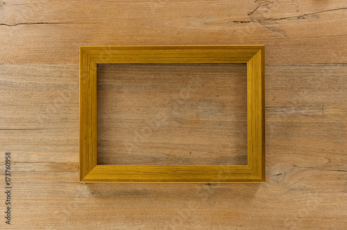 Blank Golden wooden photo frame on wooden board.
