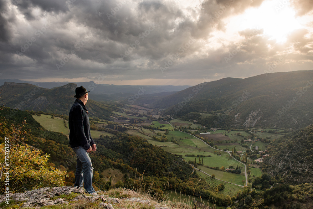 young man looking  the mountain at sunset