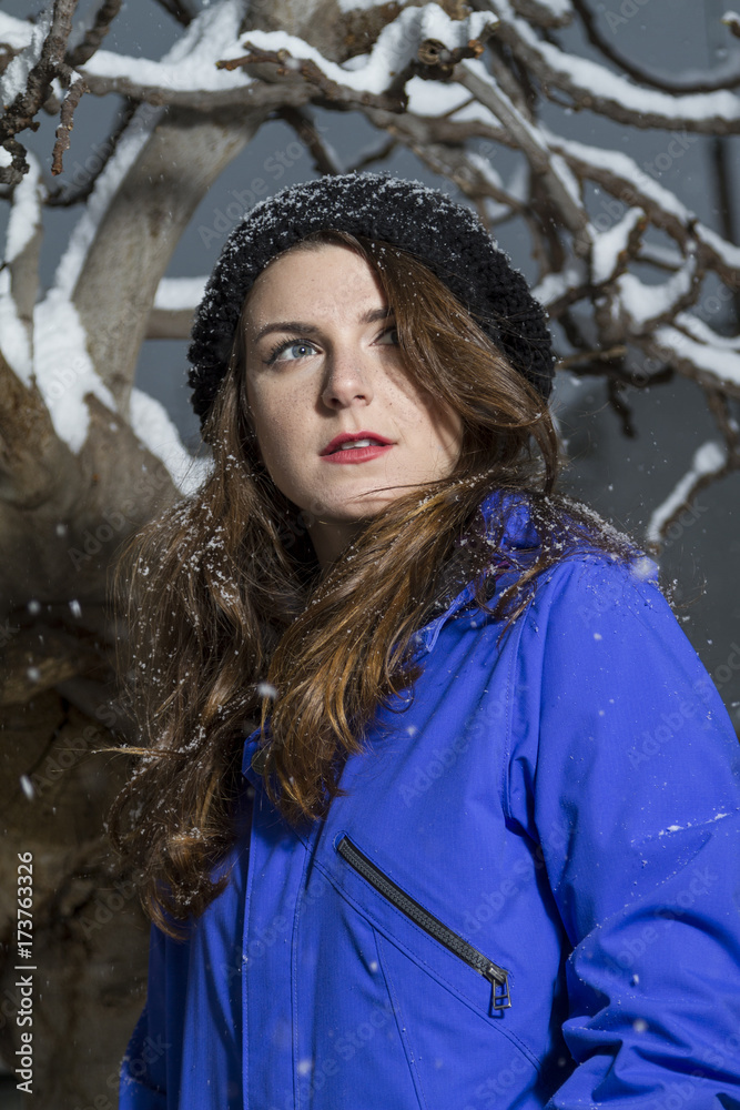 Beautiful winter portrait of young woman in the winter snowy scenery. Soft focus