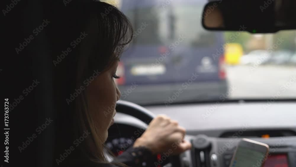 attractive girl driving a car. talking with the passenger. shooting from the back. 4k