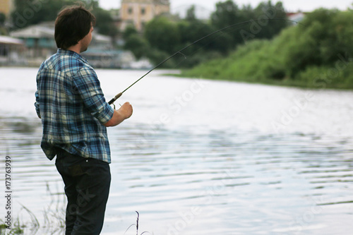 A man with a beard is fishing in the river