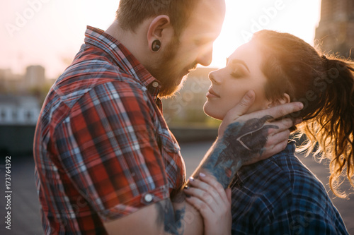 Gentle hipster couple touch. Urban background. Tender youth relationships, young people together closeup, atmospheric backlight with focus on foreground, love concept