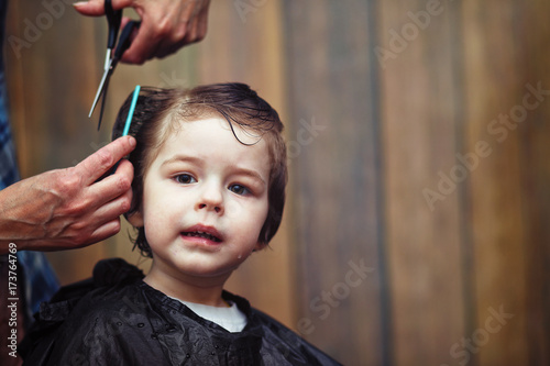 A little boy is trimmed in the hairdresser's