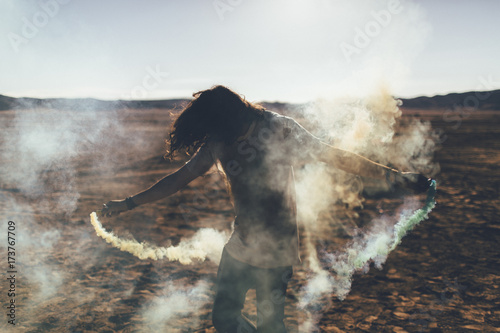 A rebellious, youthful man plays with fireworks in the desert
