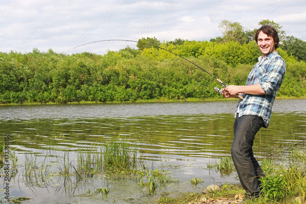 A man with a beard is fishing in the river