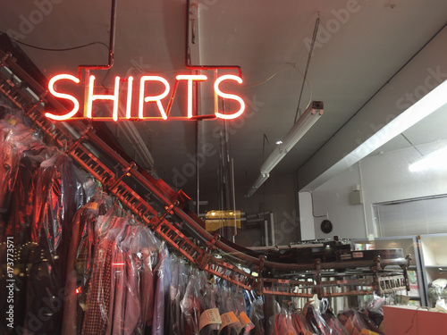Neon SHIRTS sign in window of dry cleaner business