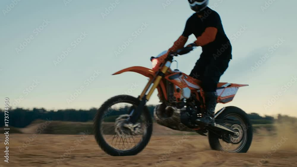 Professional Motocross Biker Drives His FMX Motorcycle Over Dunes on the Sandy Off-Road Track. Shot on RED EPIC-W 8K Helium Cinema Camera. Professional Motocross Biker Drives His FMX Motorcycle Over Dunes on the Sandy Off-Road Track. Shot on RED EPIC-W 8K Helium Cinema Camera.