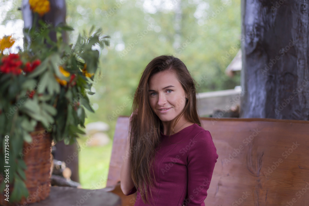 Naklejka premium beautiful girl in red dress in the greenhouse