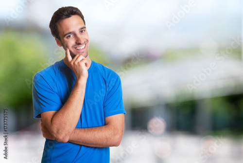 Sporty hispanic man with beard smiling at camera