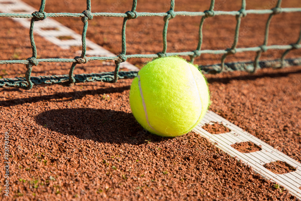 tennis ball with line and net on a sand court