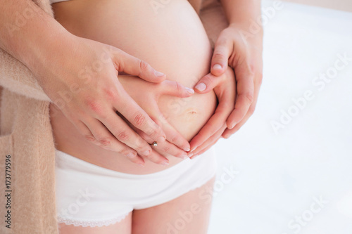 Happy parents pregnant woman heart symbol love touching tummy © Alena Popova